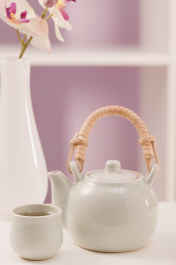 Teekanne und Teeschale, Orchidee in Vase