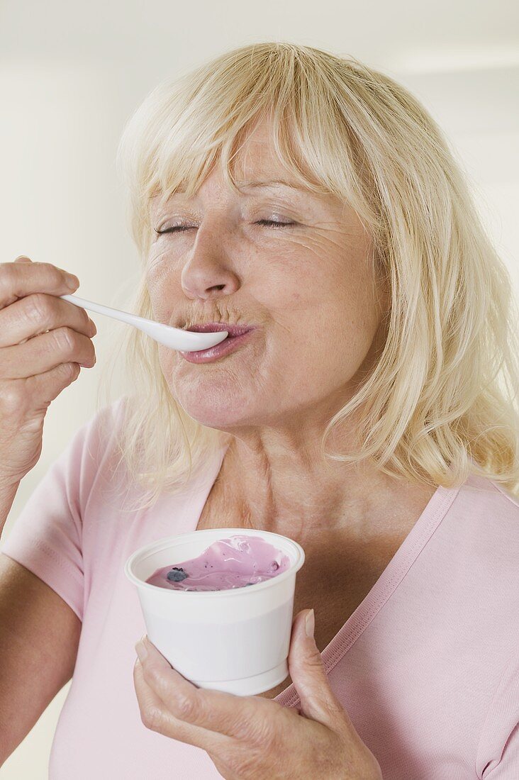 Frau isst Heidelbeerjoghurt