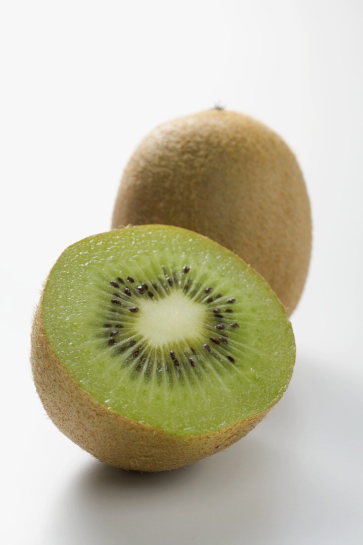 Whole kiwi fruit and half a kiwi fruit