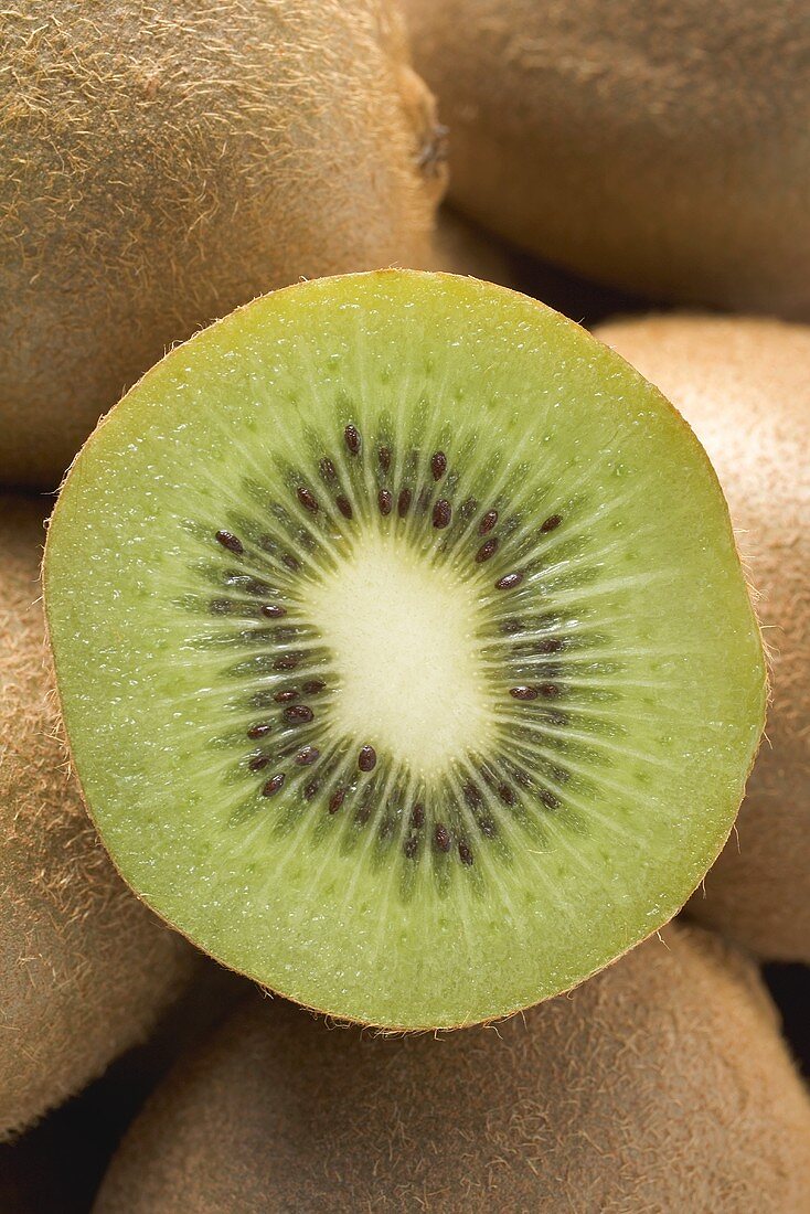 Halbe Kiwi auf mehreren ganzen Kiwis (Close Up)