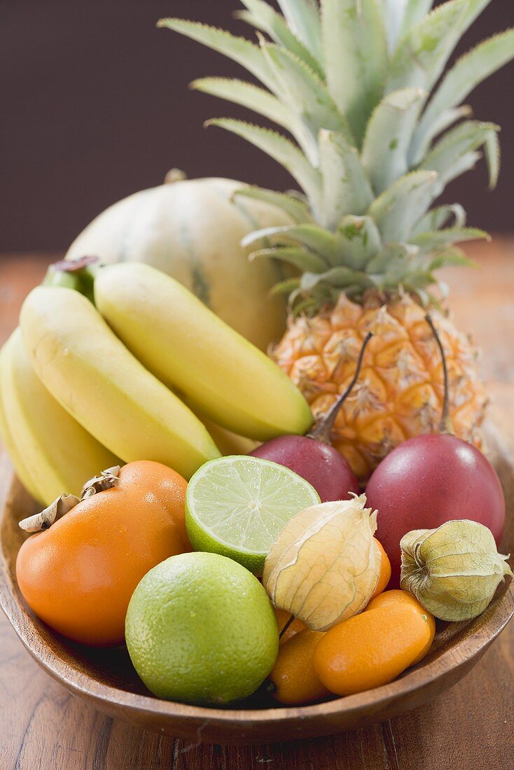 Exotische Früchte und Zitrusfrüchte in Holzschale