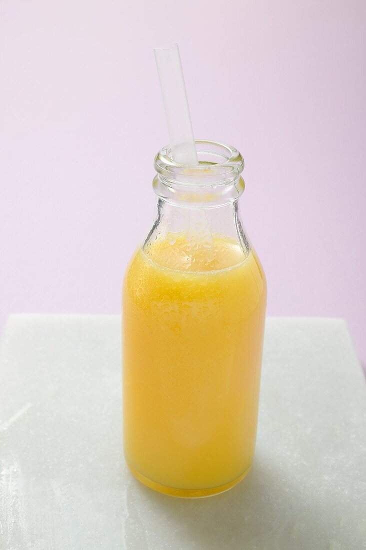 Orangensaft in Flasche mit Strohhalm
