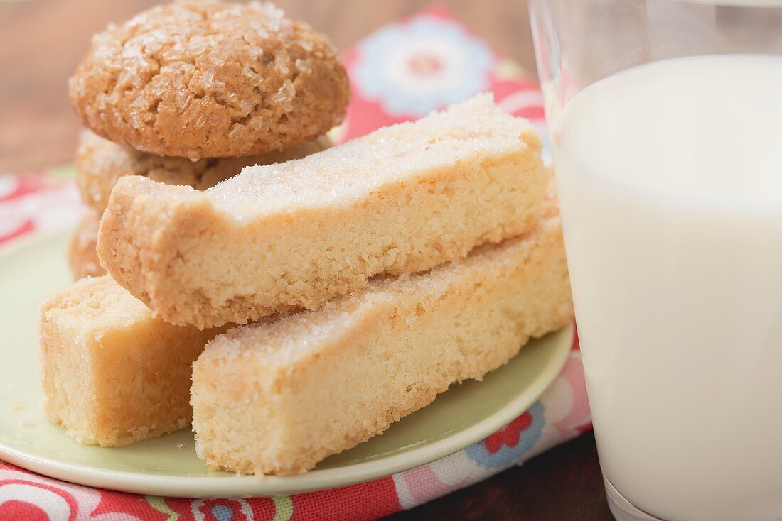Biscuits and shortbread on plate, glass of milk