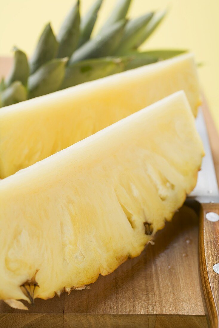Wedges of pineapple on chopping board