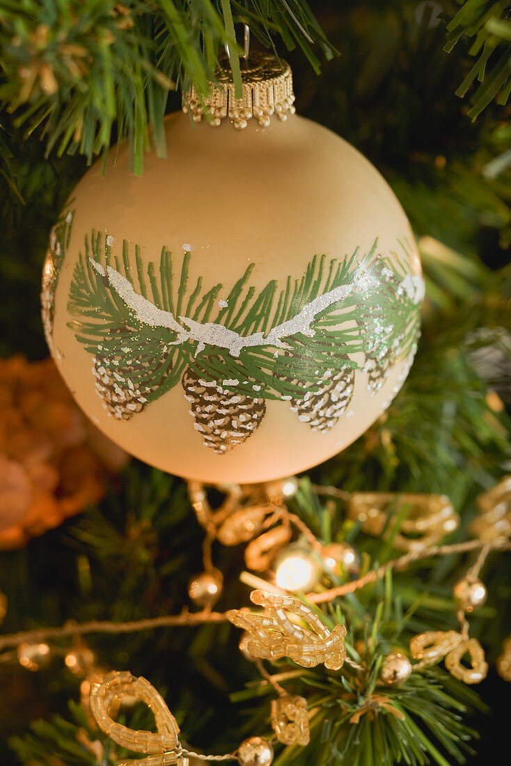 Painted bauble on artificial Christmas tree
