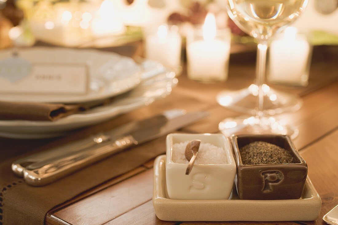 Salt and pepper beside place-setting on Christmas table