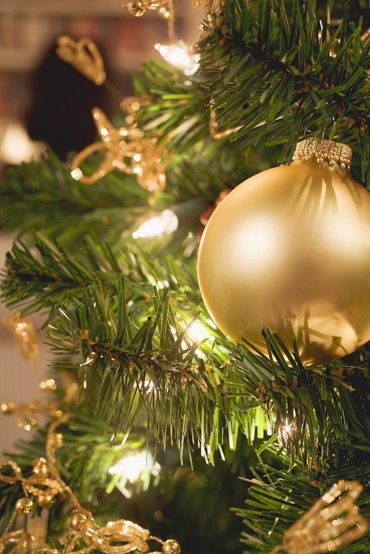 Goldfarbener Christbaumschmuck und Lichterkette