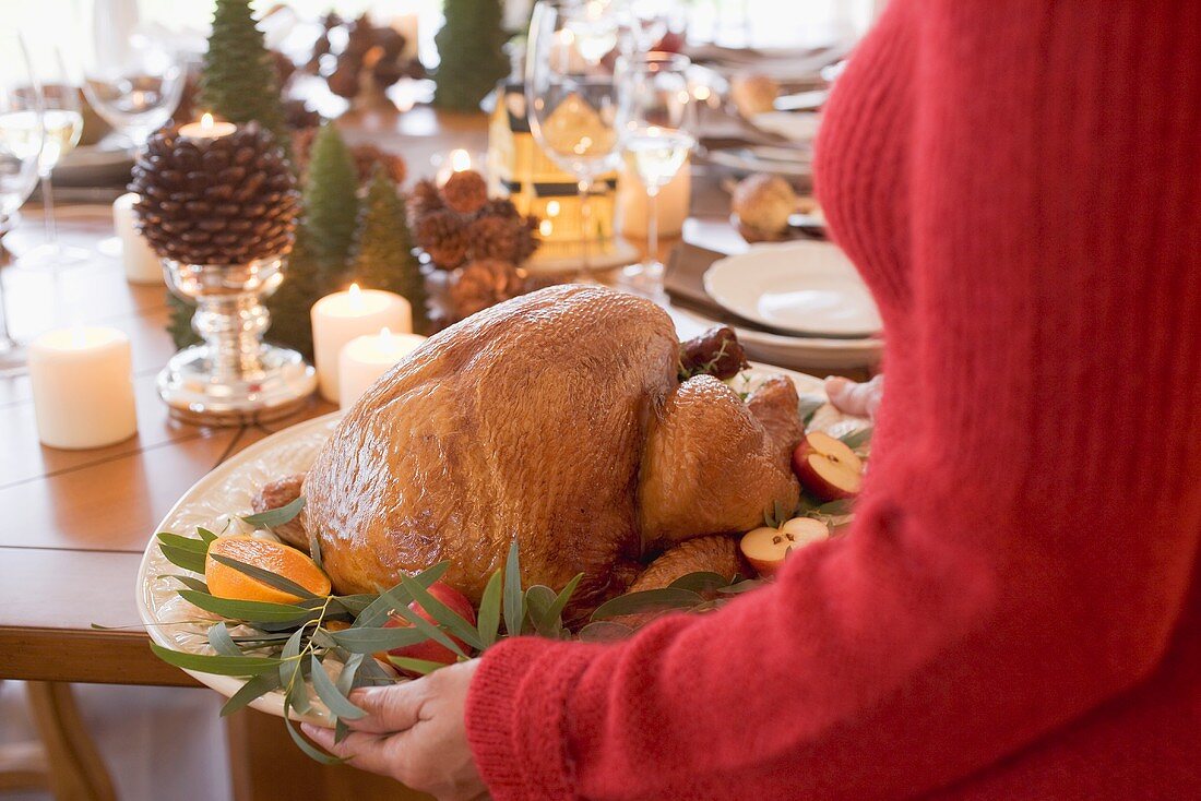 Woman serving roast turkey (Christmas)