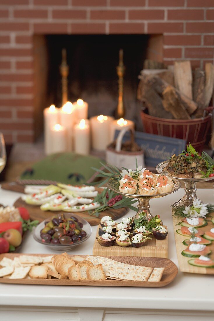 Verschiedene Häppchen auf Tisch vor Kamin (weihnachtlich)