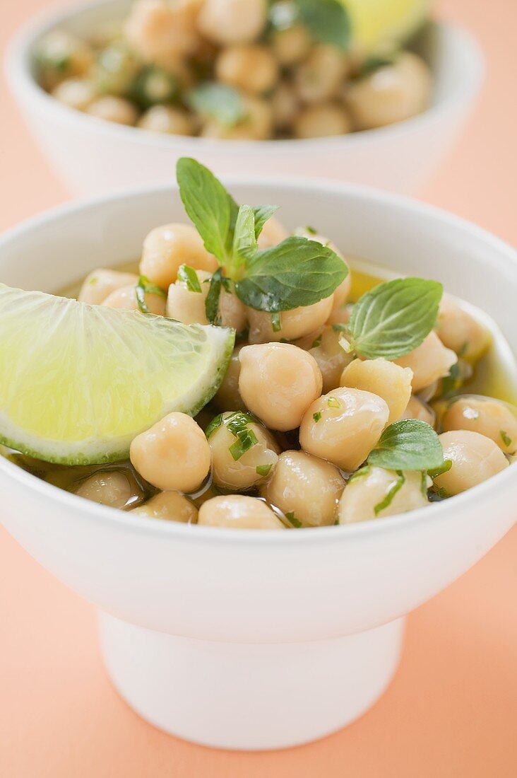 Chick-peas with lime wedges and herbs (close-up)