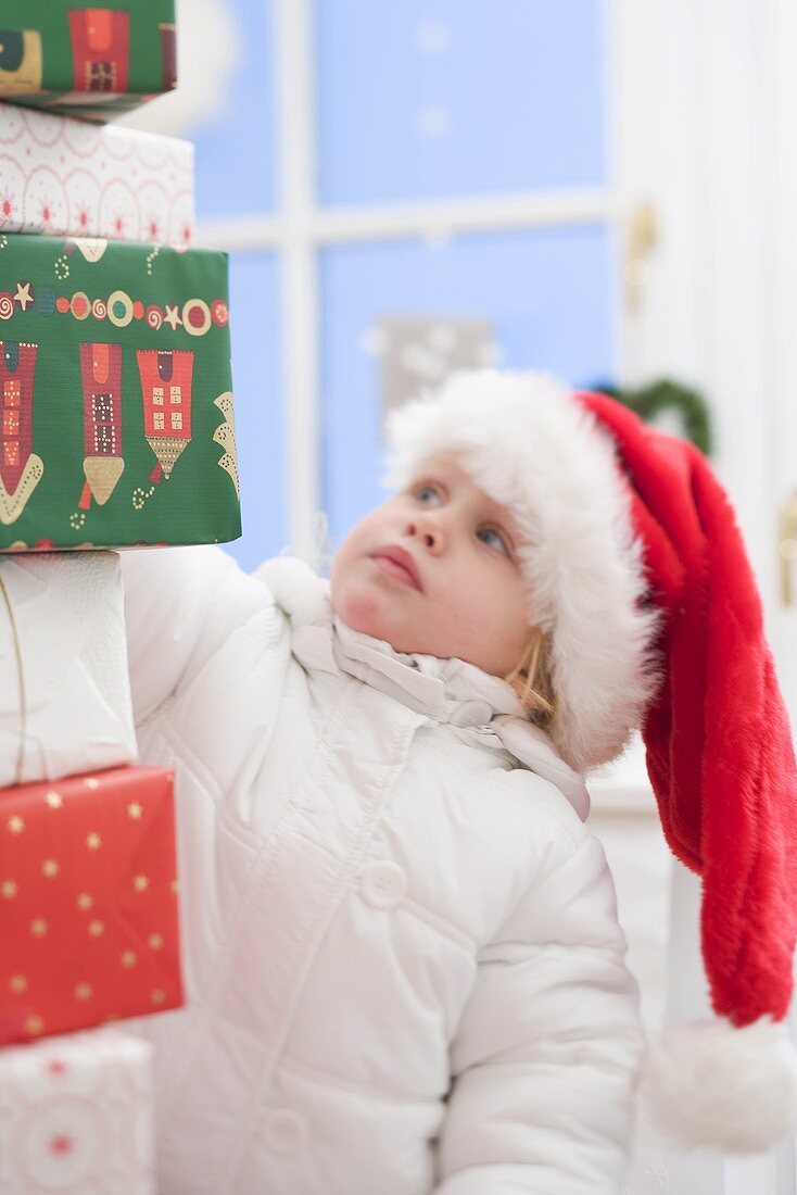 Verschiedene Weihnachtsgeschenke, Kind mit Nikolausmütze