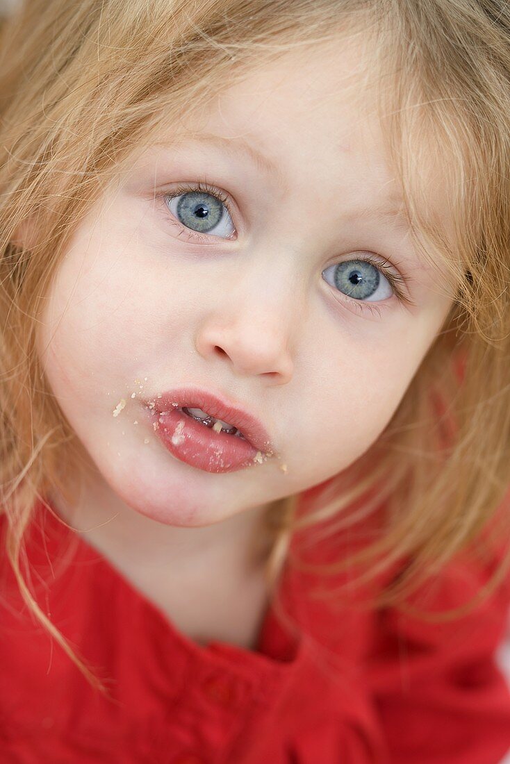 Small girl with crumbs around her mouth