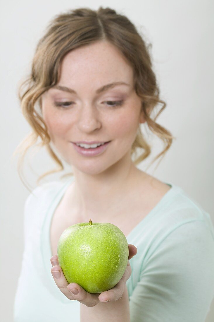 Woman holding green apple