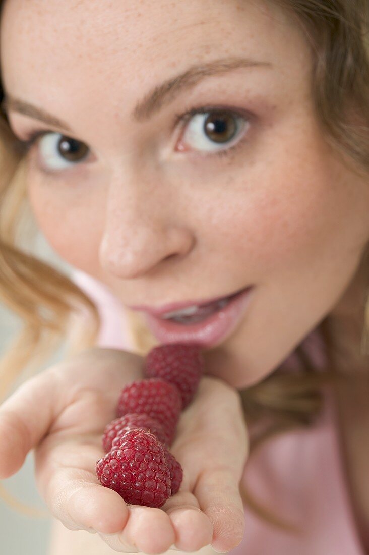 Woman holding fresh raspberries