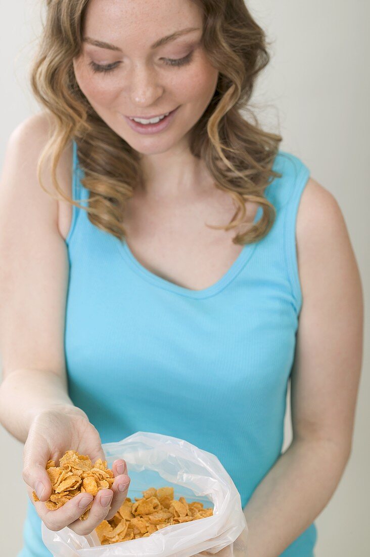 Woman taking cornflakes out of plastic bag
