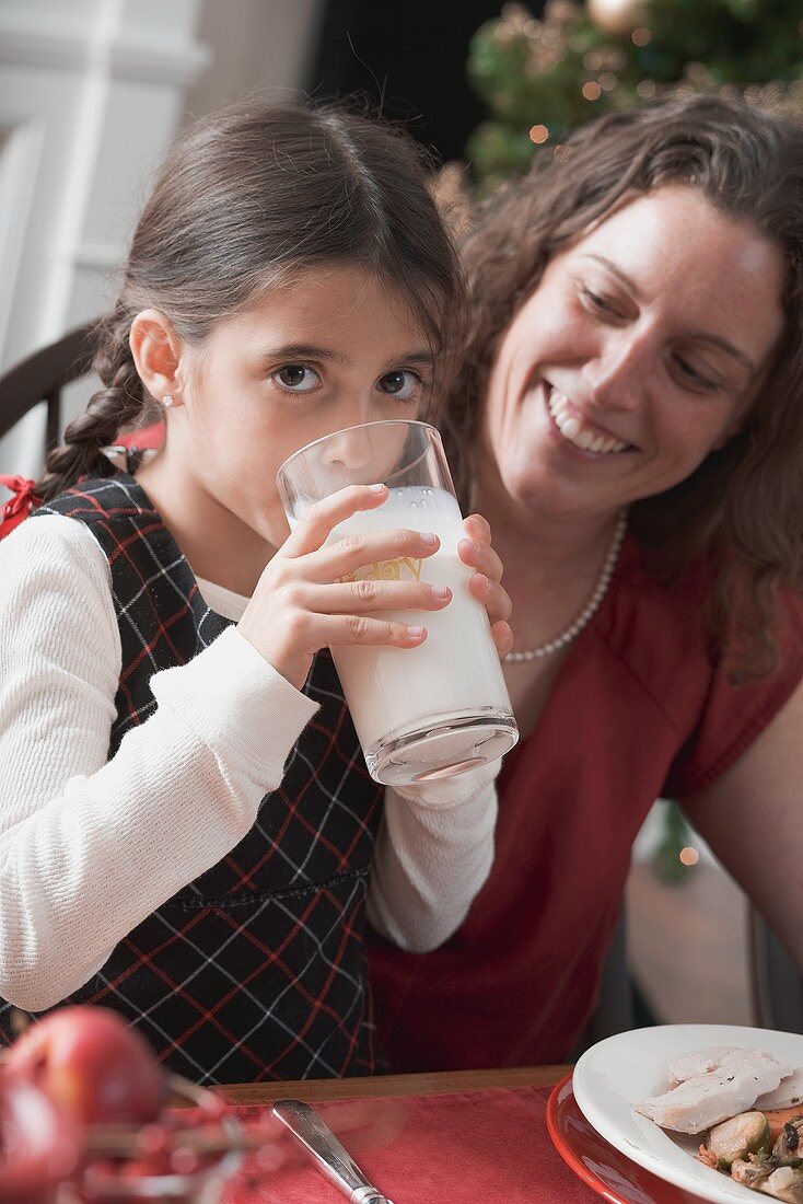 Mädchen trinkt Glas Milch beim Weihnachtsessen