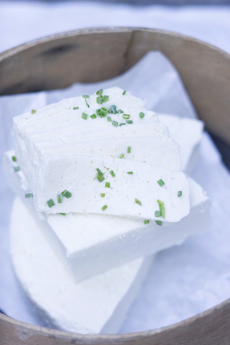 Sheep's cheese with chives in wooden basket