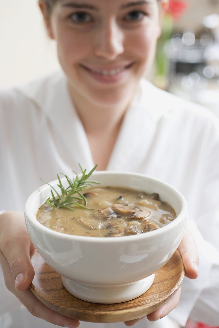 Junge Frau hält Champignonsauce