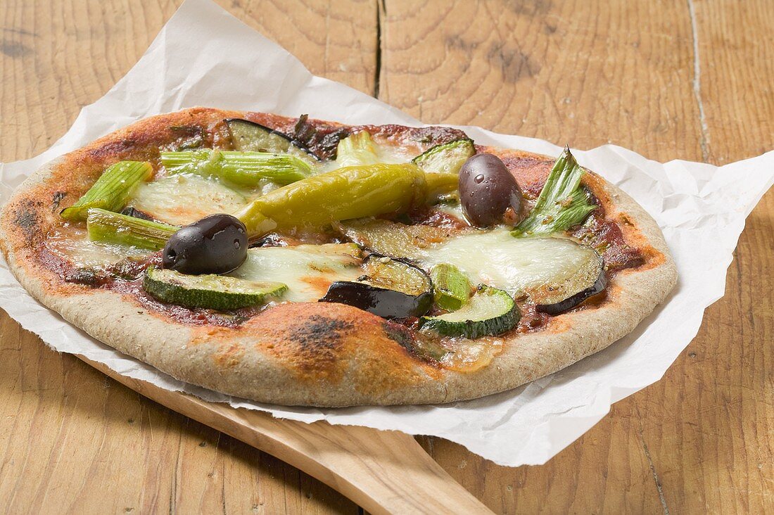 Pizza topped with courgette, aubergine, chilli and olives