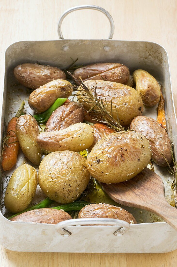 Baked potatoes in roasting tin