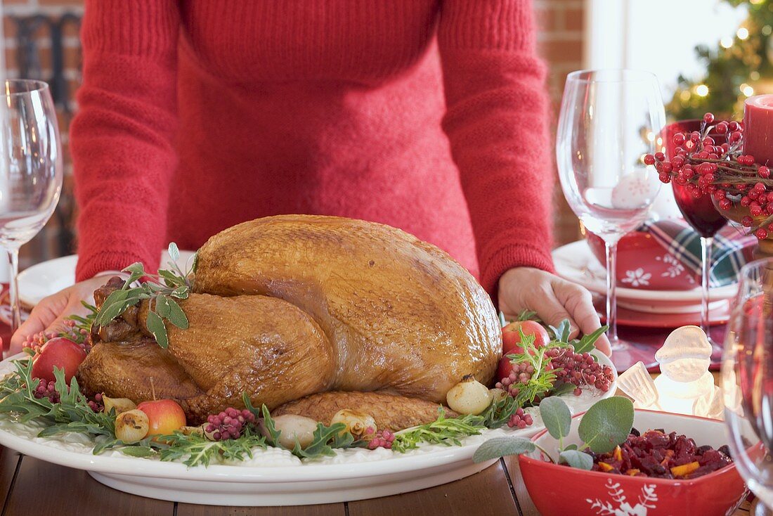 Frau serviert gebratenen Truthahn zu Weihnachten