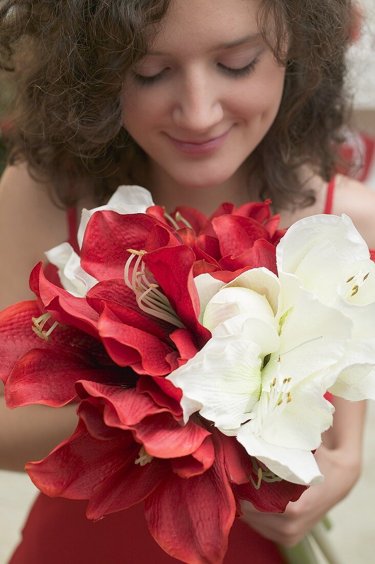 Frau hält weiße und rote Amaryllis