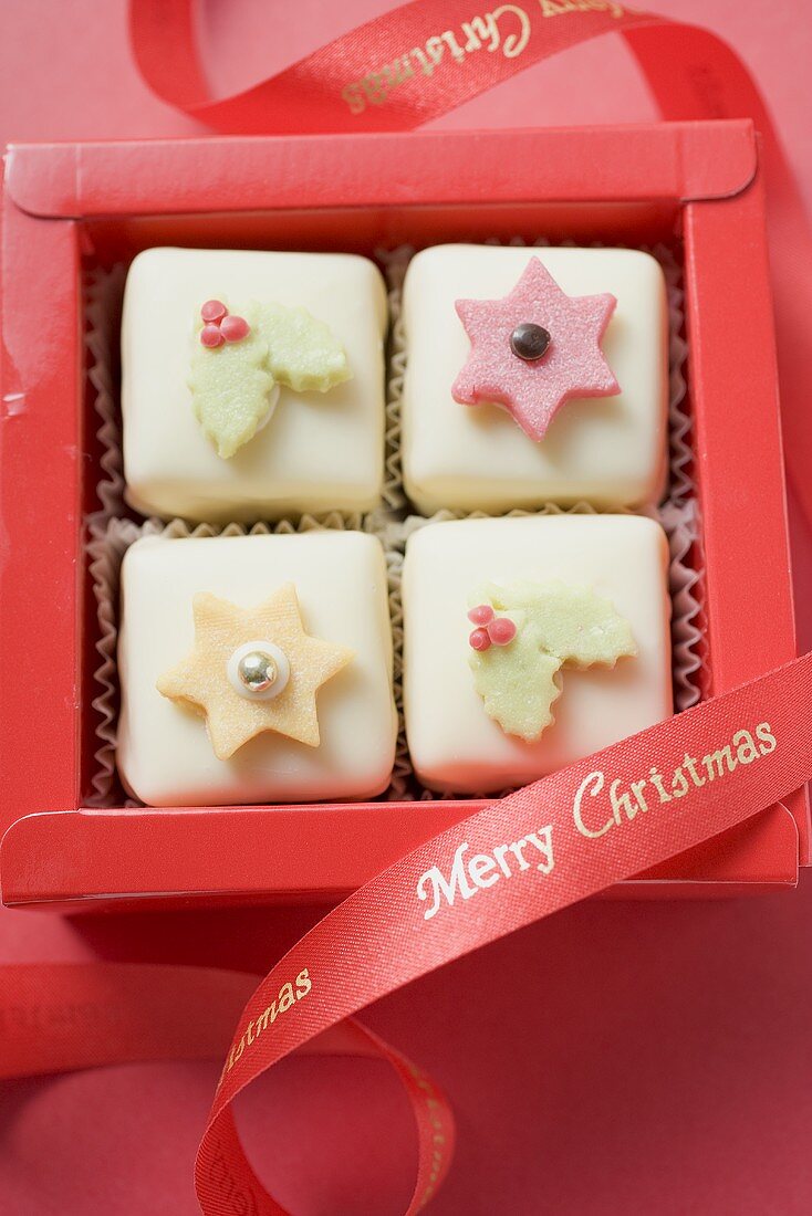 Vier weihnachtliche Petit Fours in roter Schachtel