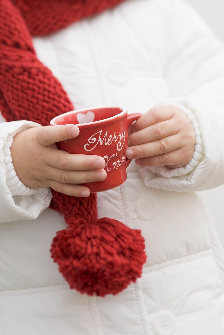 Kind hält weihnachtliche Tasse