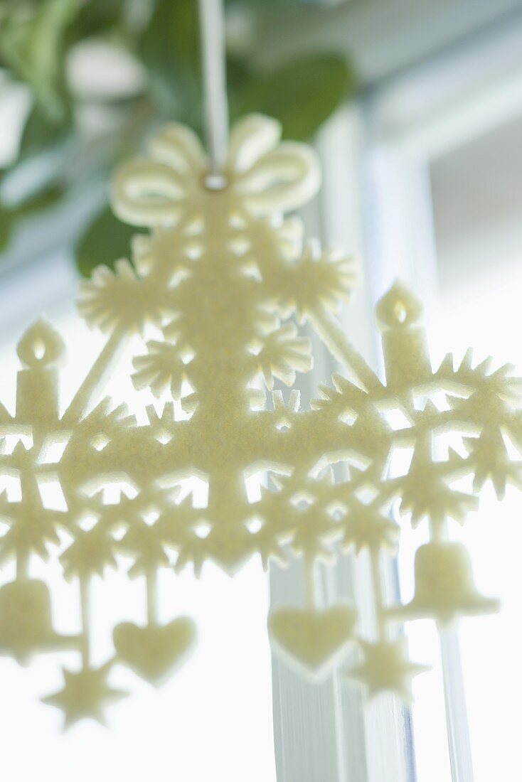 White felt Advent wreath in front of a window