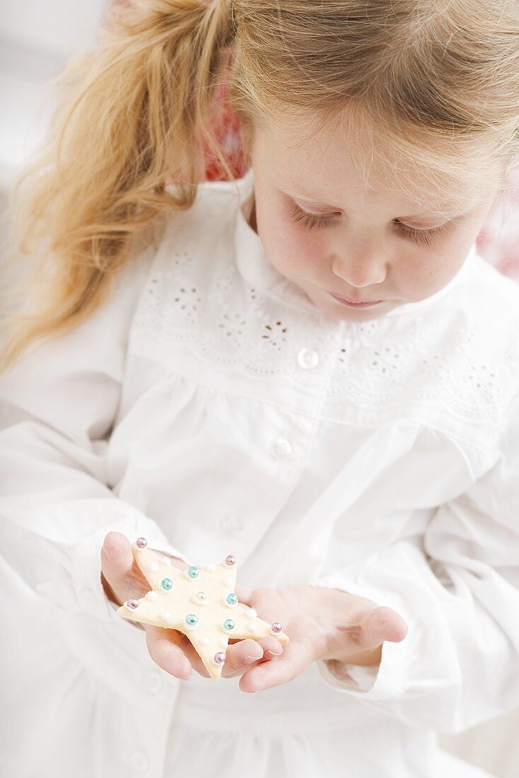 Small girl holding Christmas biscuit