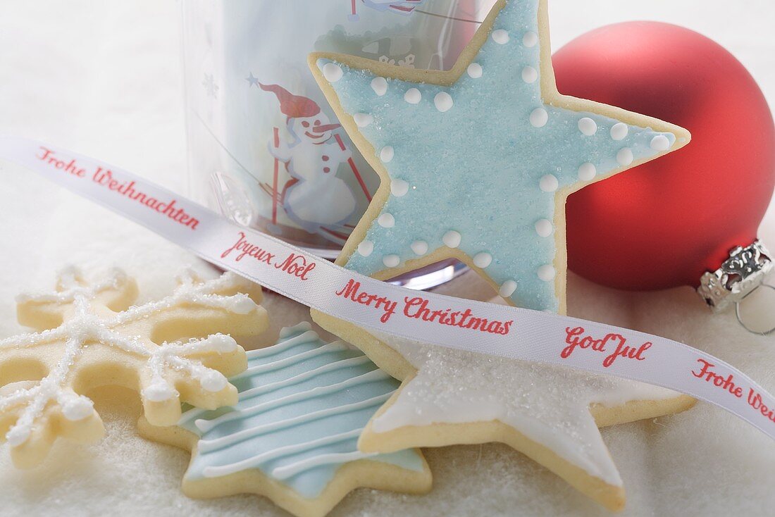 Christmas biscuits in front of glass, ribbon & Christmas bauble