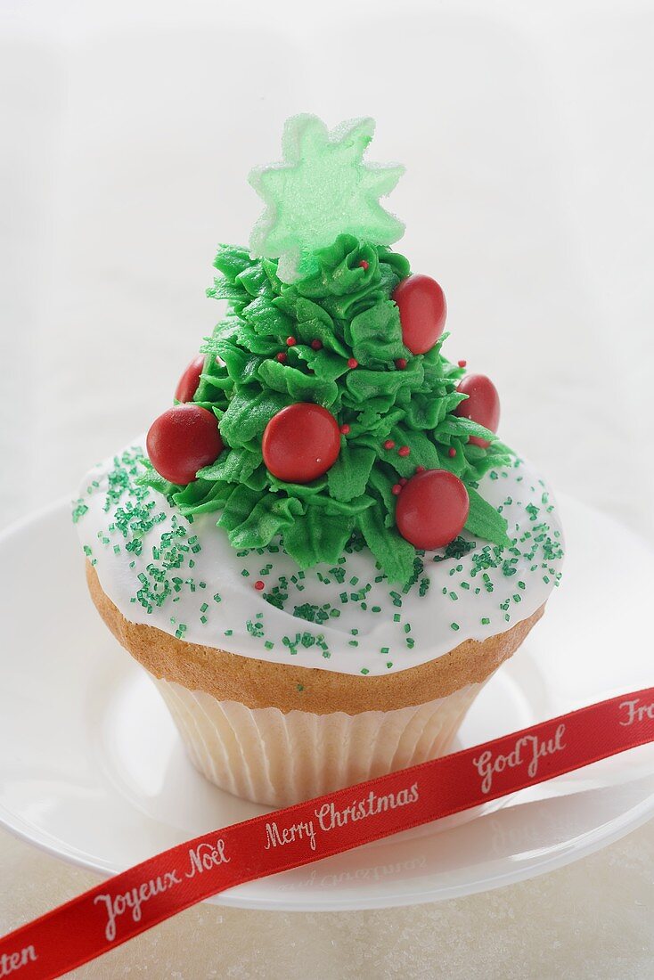 Cupcake, weihnachtlich verziert, auf Teller mit Schleife