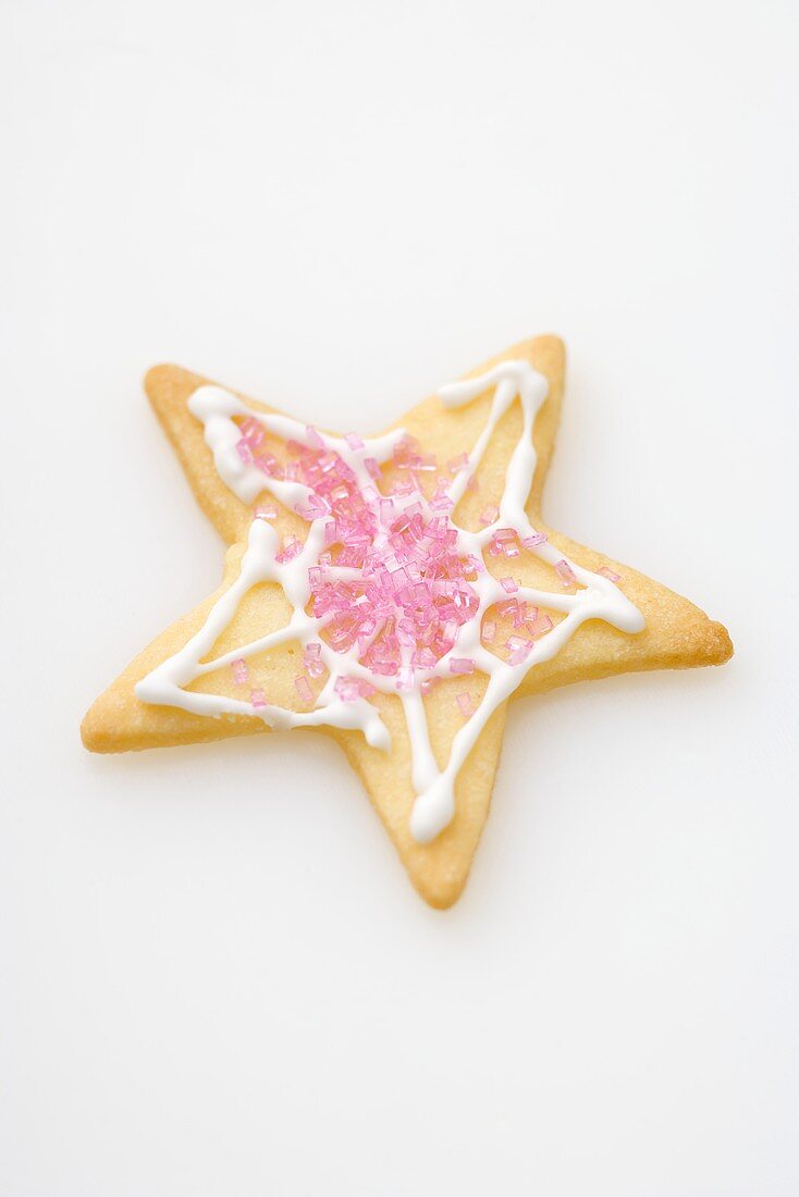Ein Sternplätzchen, verziert mit rosa Zucker