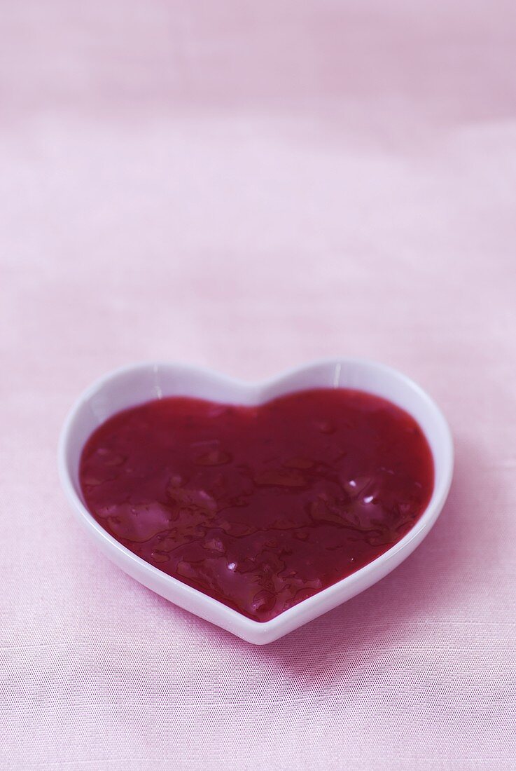 Strawberry jam in heart-shaped dish