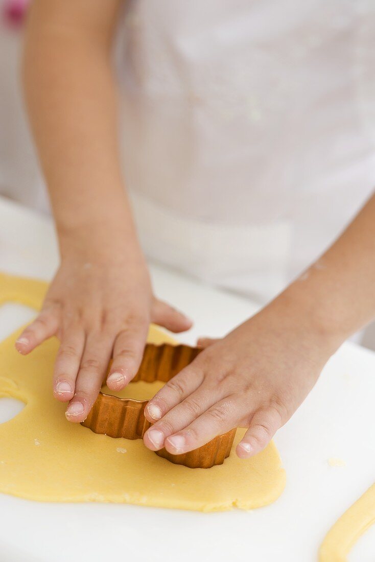 Child cutting out a biscuit