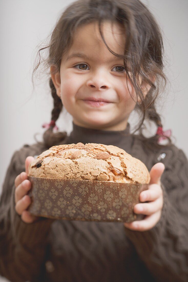 Small girl holding Christmas cake