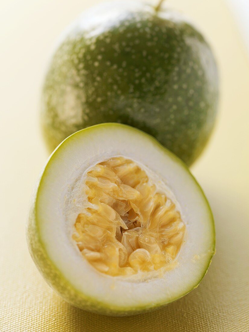 Green passion fruit, whole and halved