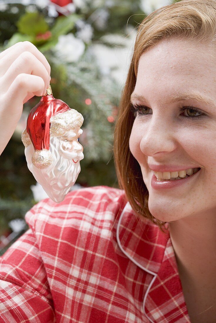 Woman holding Christmas tree ornament (Father Christmas)