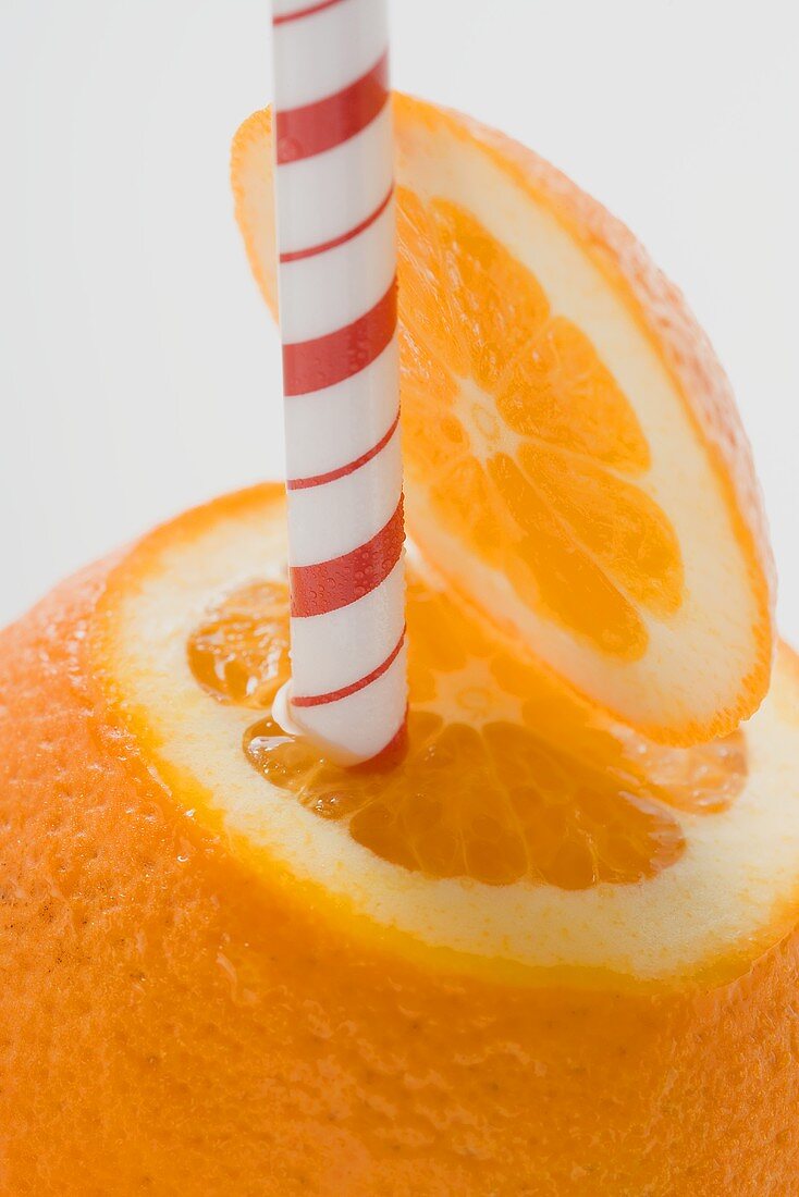 Orange with straw (close-up)