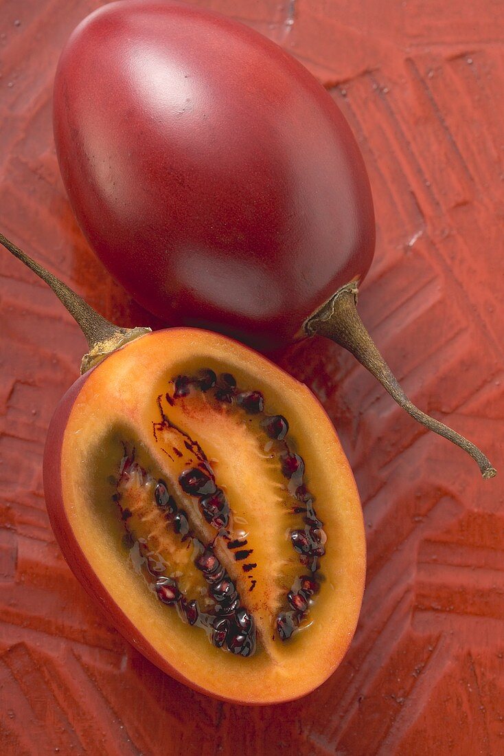 Whole tamarillo and half a tamarillo