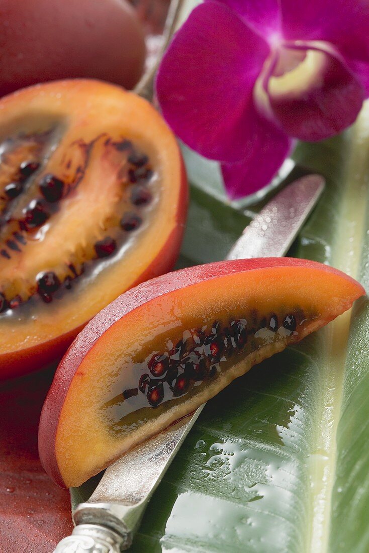 Tamarillos, half and a wedge on knife