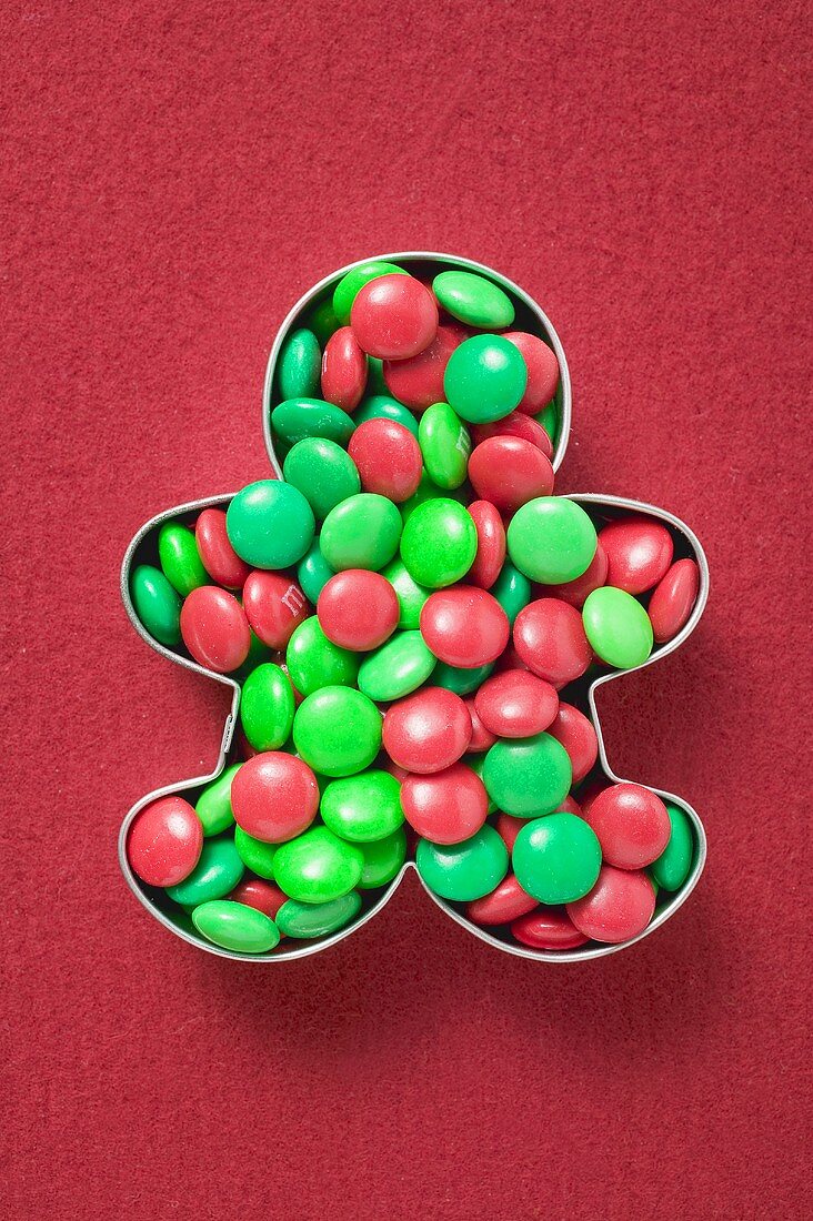 Red and green chocolate beans in biscuit cutter