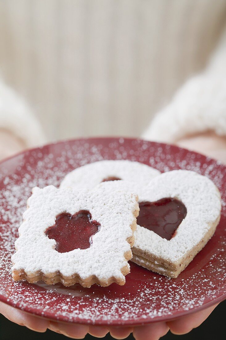 Frau hält Marmeladenplätzchen auf Teller