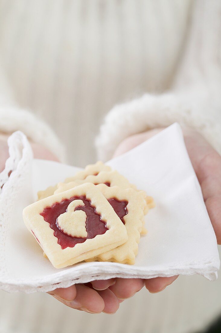 Woman holding jam biscuits on fabric napkin