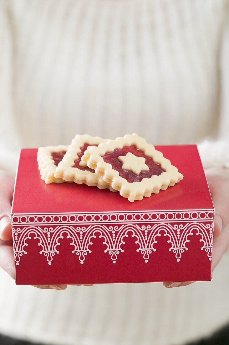 Woman holding jam biscuits on red box