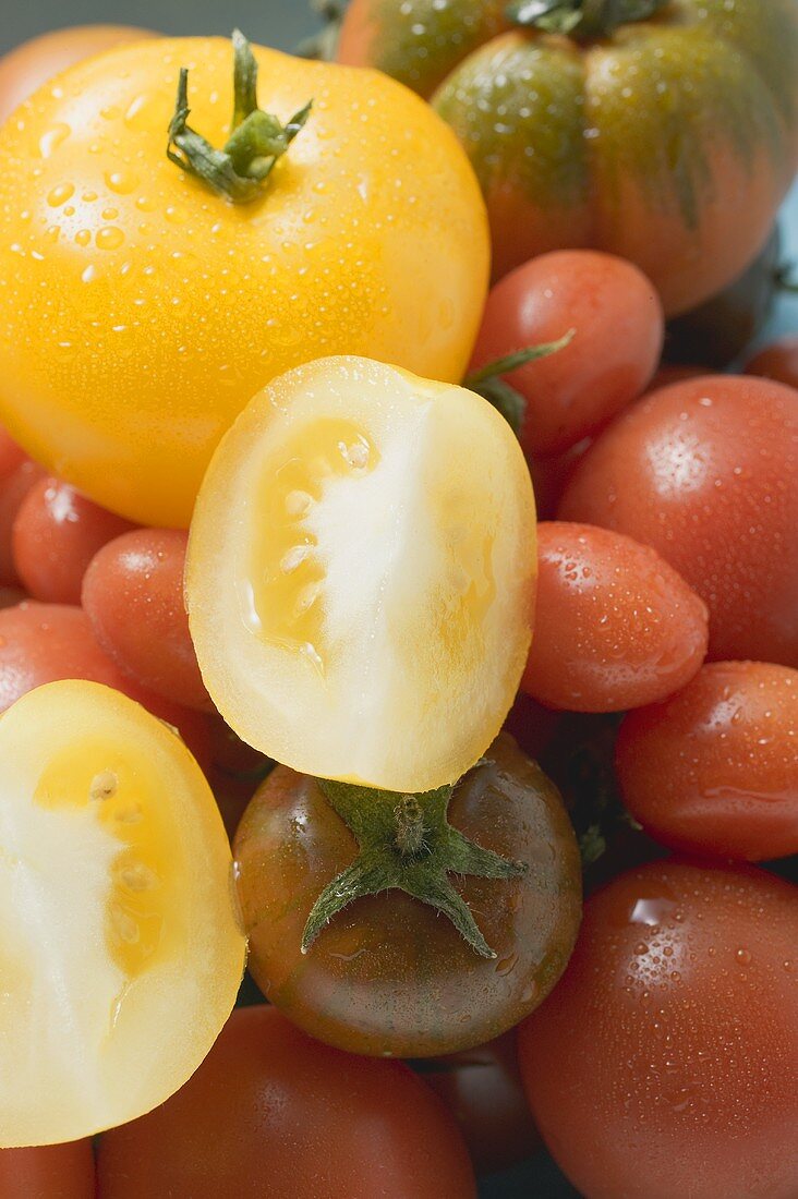 Various types of tomatoes with drops of water