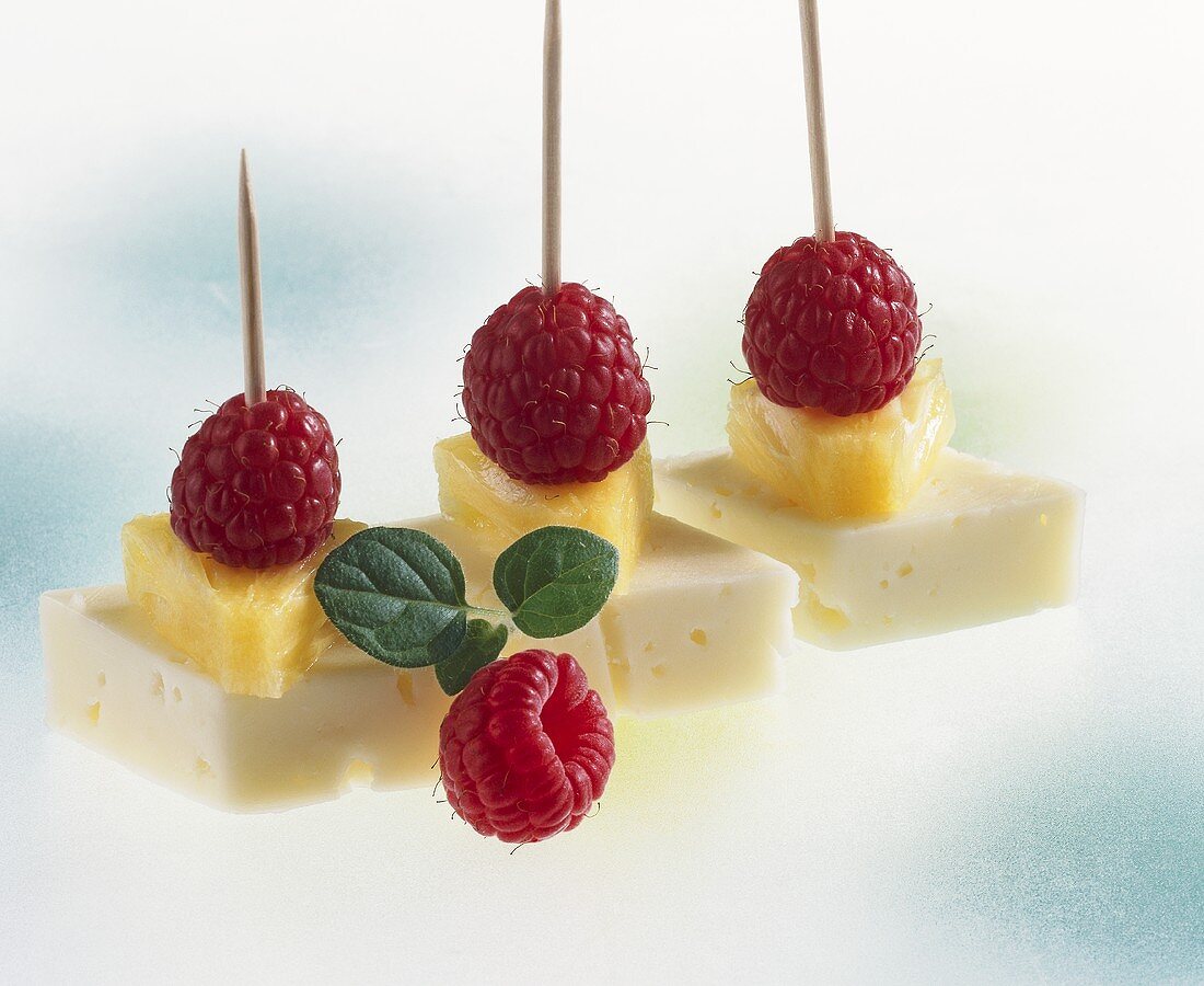 Cheese, pineapple and raspberries on cocktail sticks