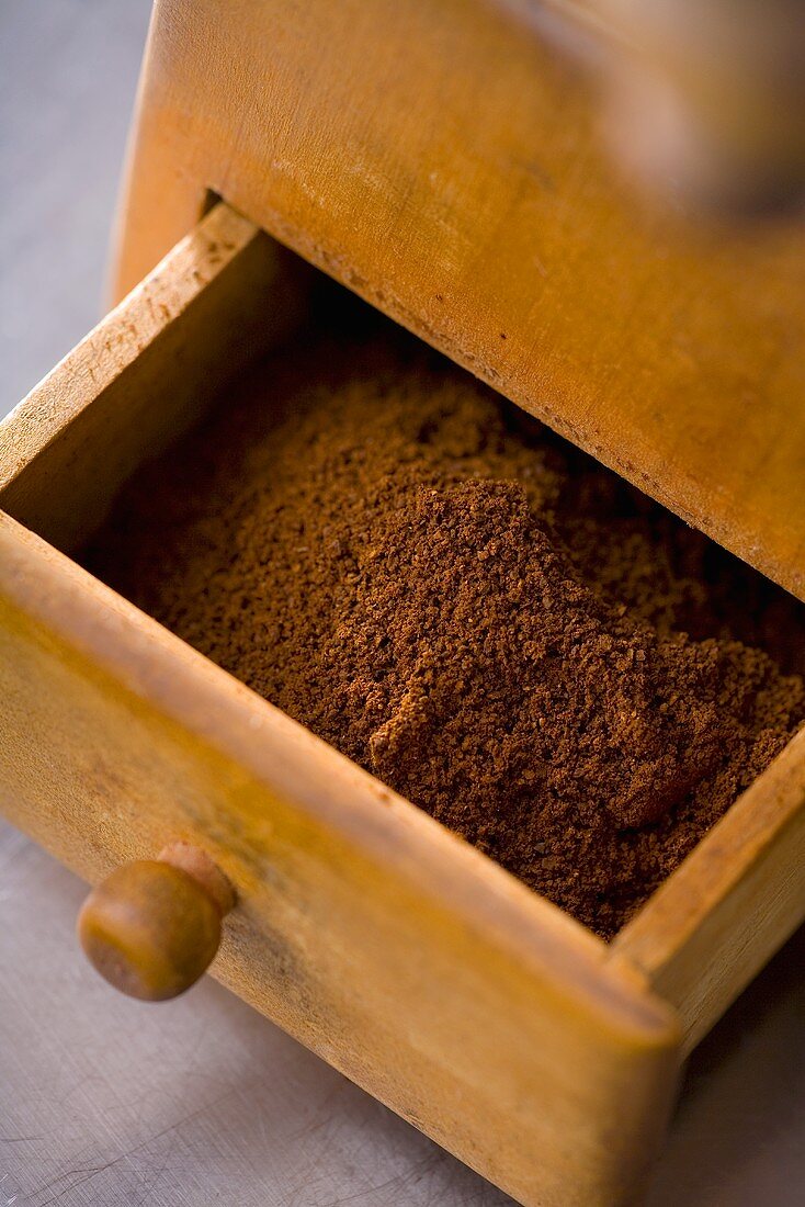 Ground coffee in the drawer of an old coffee mill