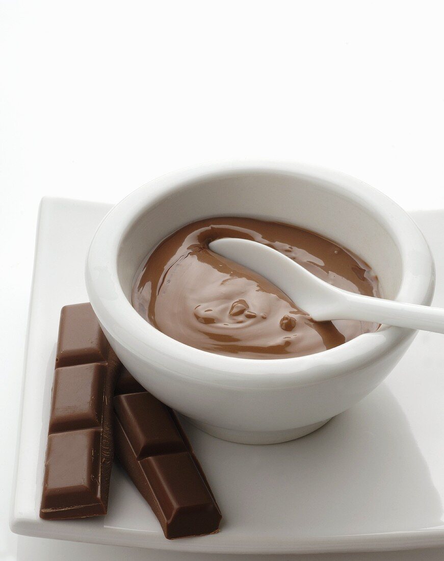 Chocolate mask in small bowl and pieces of chocolate