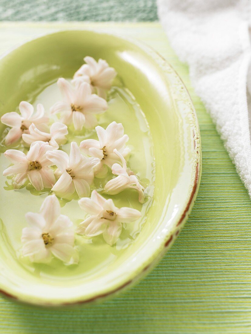 Lindgrüne Schale mit Hyazinthenblüten im Badezimmer